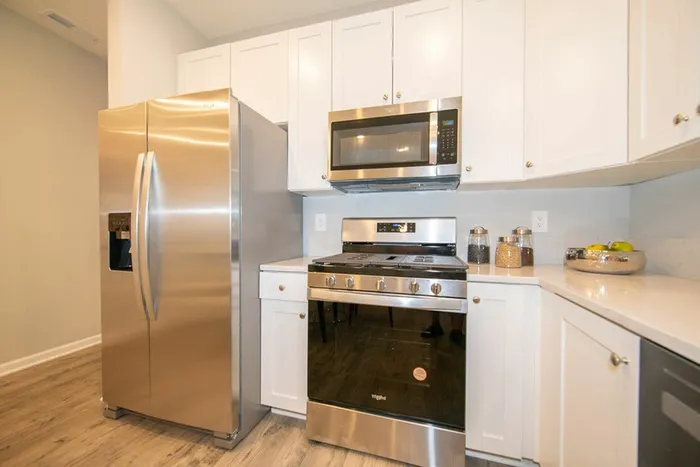 Homes for Rent in Avon, IN - Woods at Countryside Crossing - Kitchen With Stainless Steel Appliances, Hardwood-Style Flooring, White Cabinets, and Granite Countertops