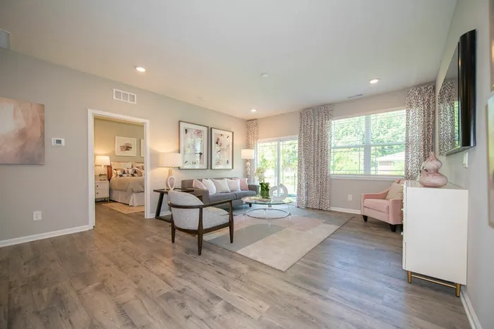 Furnished living room with windows, sliding glass door, rug, couch, and lamps