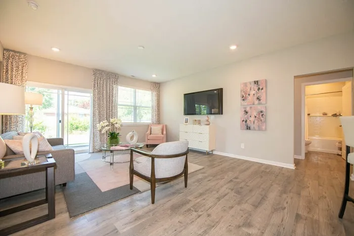 4-BR Homes for Rent in Avon, IN - Woods at Countryside Crossing - Furnished Living Room With Windows, Sliding Glass Door, and Hardwood-Style Flooring