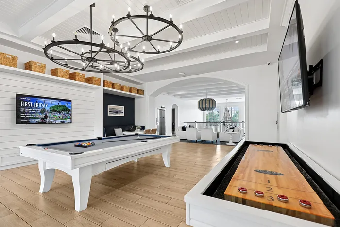 Indoor community club house with pool table, shuffleboard and seating areas