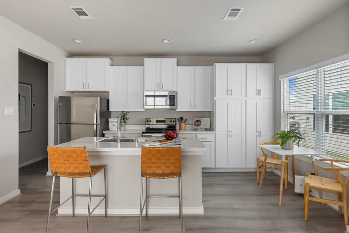 Furnished kitchen with island and barstools