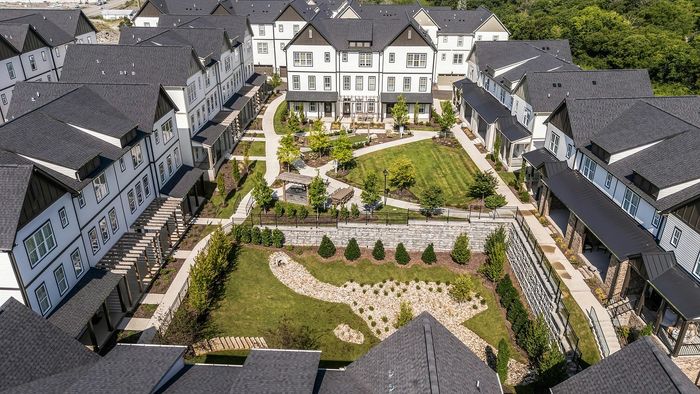 Charming apartment complex featuring modern townhouses, lush landscaped gardens, and inviting outdoor spaces, perfect for vibrant community living.