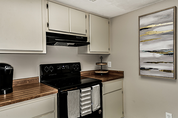 Kitchen with white cabinets and wood countertops