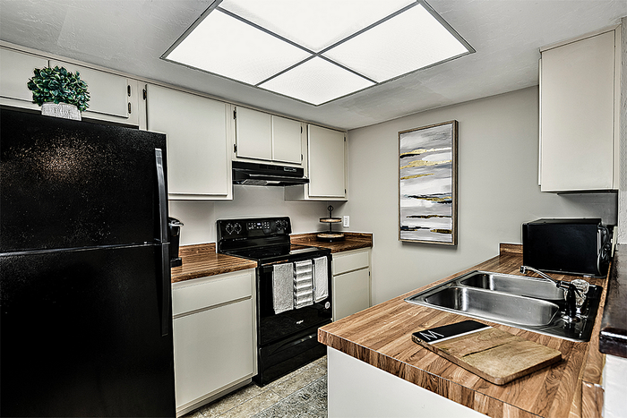 Kitchen with white cabinets and wood countertops