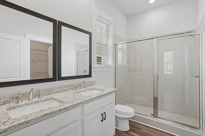 granite countertops in bathroom with large mirror and stand-up shower