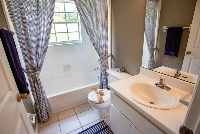 Bathroom with tub and white cabinets