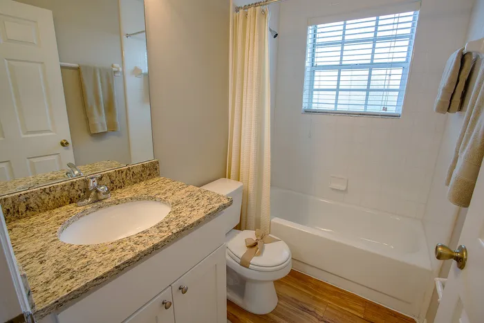 Bathroom with tub and white cabinets
