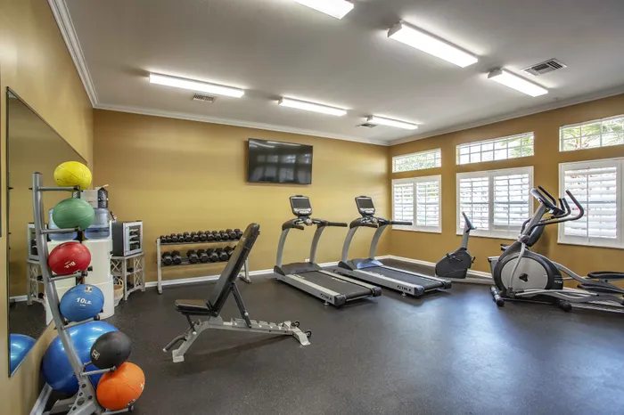 fitness center with cardio machines and free weights