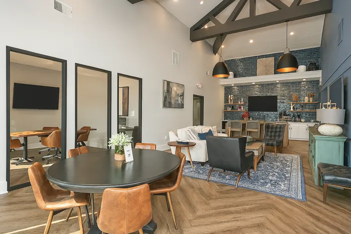 Stylish modern clubroom area in an apartment complex with high ceilings and elegant furnishings.