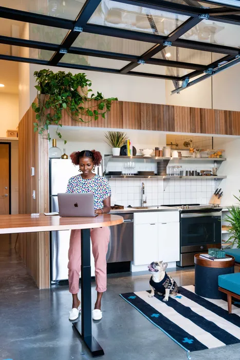 woman working in her kitchen with her dog