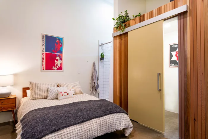 stylish bedroom next to barn door to bathroom