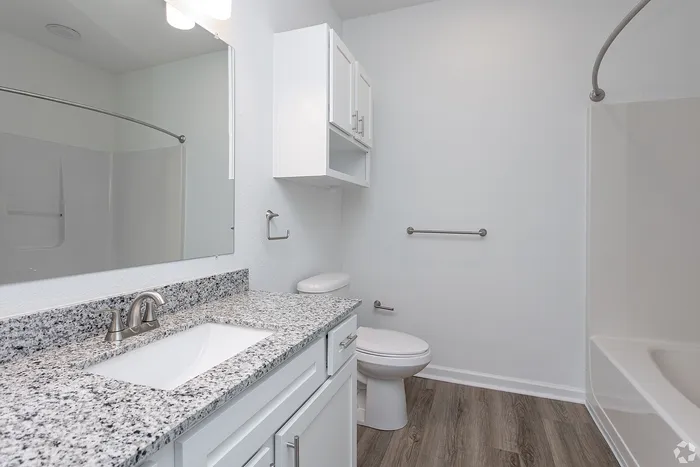bathroom with tub and marble countertops