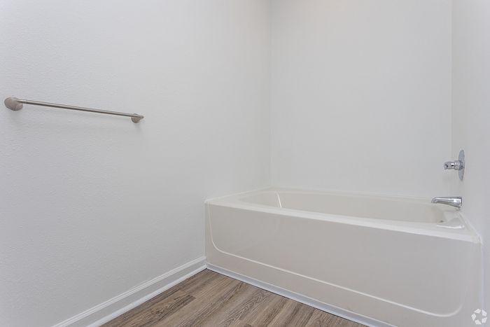 bathtub with vinyl flooring in bathroom