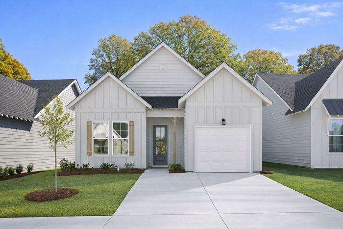 New cottage-style home for rent at Champions Square Homes in Opelika, AL with attached garage and modern exterior.