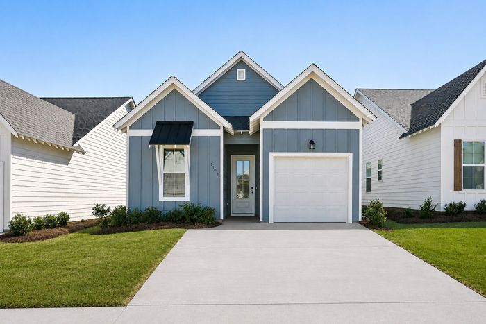 Blue cottage-style rental home with attached garage at Champions Square Homes in Opelika, AL
