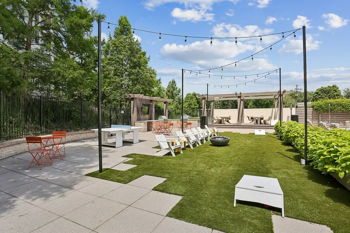 outdoor green area with seating and cornhole