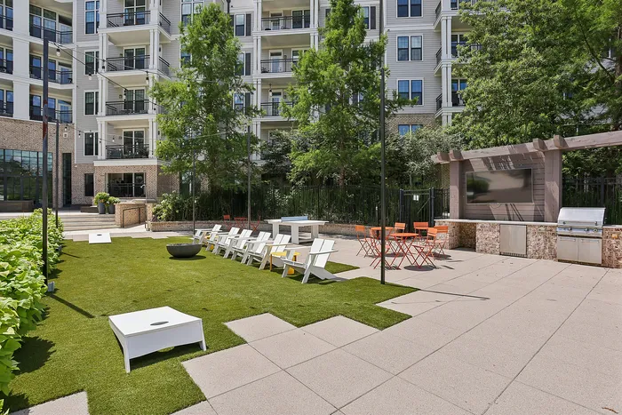 outdoor green area with seating and cornhole