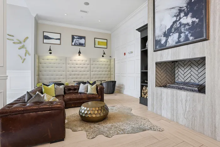 lounge space with brown leather couch and fireplace