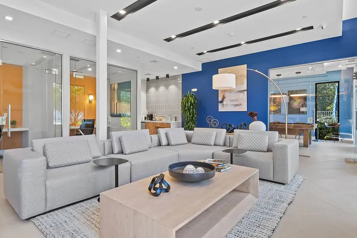 Chic and modern lounge area featuring stylish gray sofas, elegant decor accents, and vibrant blue wall for a contemporary vibe.