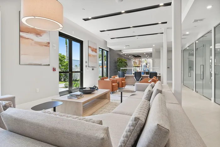 Bright and modern lounge area featuring elegant furnishings, cozy seating, and large windows with garden views.