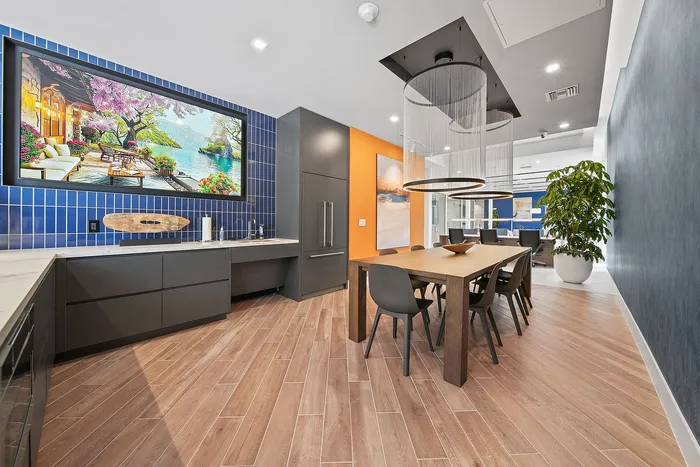 Modern dining area with chic decor, featuring a large wooden table, elegant lighting fixtures, and artistic wall art, perfect for a stylish urban lifestyle.