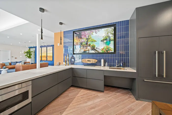 Modern kitchen with sleek cabinets, stylish backsplash, and a bright open living area featuring elegant decor and natural lighting.