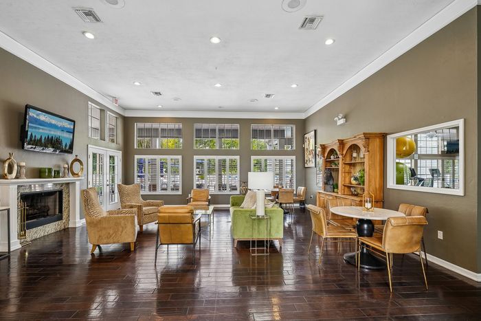 Chic and inviting living area with elegant armchairs, a fireplace, and abundant natural light from large windows, perfect for relaxation and entertaining.