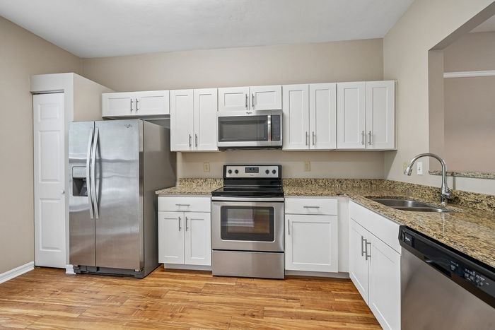 Chic modern kitchen with stainless steel appliances, sleek granite countertops, and stylish white cabinetry.