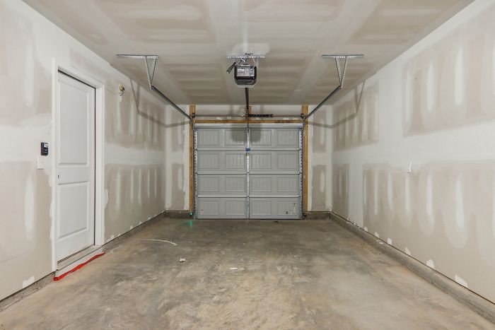 Spacious, modern garage with sleek concrete flooring and a contemporary automatic door.