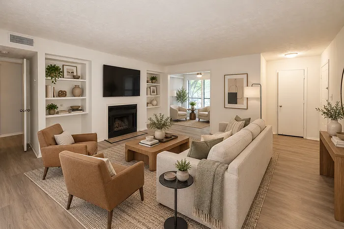 Inviting living room with modern decor, cozy fireplace, and abundant natural light, leading to a bright sunroom.