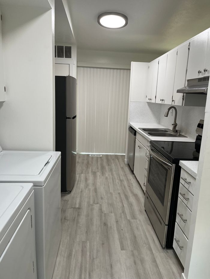Contemporary kitchen with sleek stainless-steel appliances, modern cabinetry, and elegant wood flooring, perfect for culinary enthusiasts.