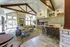 Inviting community space with rustic beams, elegant kitchen bar, cozy seating, and abundant natural light.