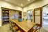 Inviting dining area with a rustic wooden table, elegant seating, and a charming bookcase; perfect for cozy gatherings.