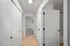 Bright hallway with wooden flooring, white doors