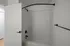 Modern bathroom with a pristine white bathtub and matte black fixtures.