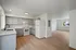 Bright, modern open-concept kitchen and living area with sleek gray cabinets and quartz countertops.