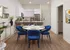 Stylish open-concept kitchen and dining area with blue velvet chairs, a marble table, and modern decor.