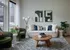 Montgomeryville apartment iving room with a white sofa, green chairs, abstract wall art, and a wooden coffee table.