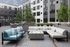 Modern apartment courtyard with stylish outdoor seating, lush greenery, and trendy brick flooring, perfect for relaxation and social gatherings.