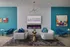 Luxor Lifestyle Apartments lounge area showcasing modern furniture, vibrant artwork, and a sleek wall fireplace in a stylish teal and white setting.
