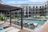 Modern apartment complex with a stunning outdoor pool and sun loungers, perfect for relaxation and leisure.