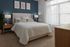 Elegant bedroom with a plush queen-sized bed, accentuated by modern nightstands and soothing blue walls.
