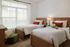 Bright and cozy twin bedroom with natural light, stylish wooden frames, and charming decor.