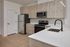 Elegant modern kitchen featuring sleek stainless steel appliances, chic wooden cabinetry, and a stylish black faucet.