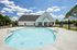 pool with home behind it on sunny day