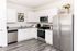 Upscale kitchen with white cabinetry and stainless steel appliances
