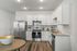 Open Kitchen with Stainless Steel Appliances and White Cabinetry