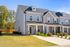 Exterior two-story townhomes with porch and driveway on a sunny day