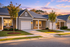 Charming suburban homes with welcoming porches and well-maintained lawns at sunset.