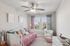 Furnished bedroom with daybed and desk with ceiling fan